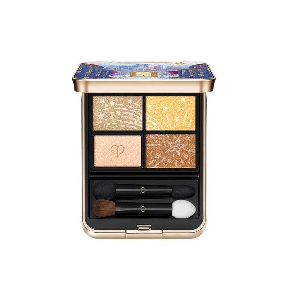 Photo of the 26 AW Holiday Collection limited-edition EYE COLOR QUAD. The opened gold compact reveals a four-shade eyeshadow palette and two applicators below. Three shades feature engraved star patterns, while one shade is embossed with the brand logo.